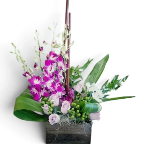 Purple orchids and pale roses arranged in a wooden box
