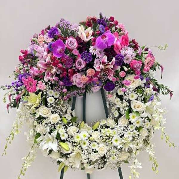 Large floral wreath on an easel with pink, purple, and white flowers