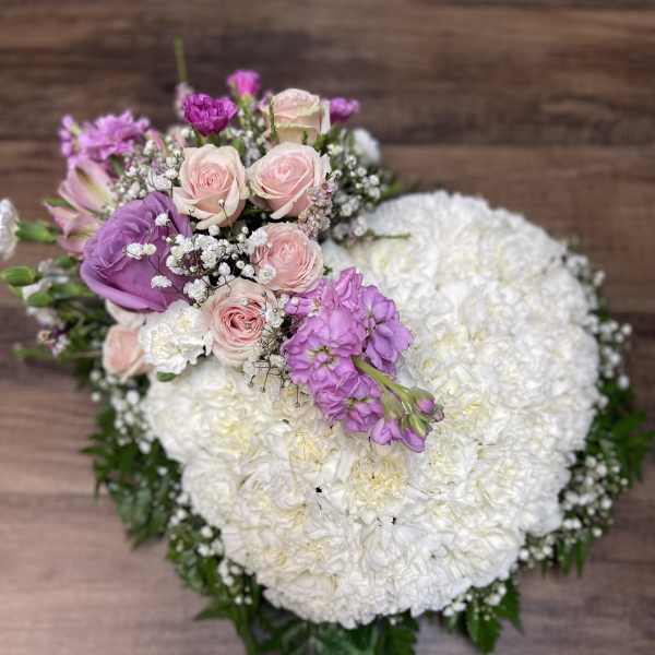 Heart-shaped bouquet of white and pink flowers with purple accents