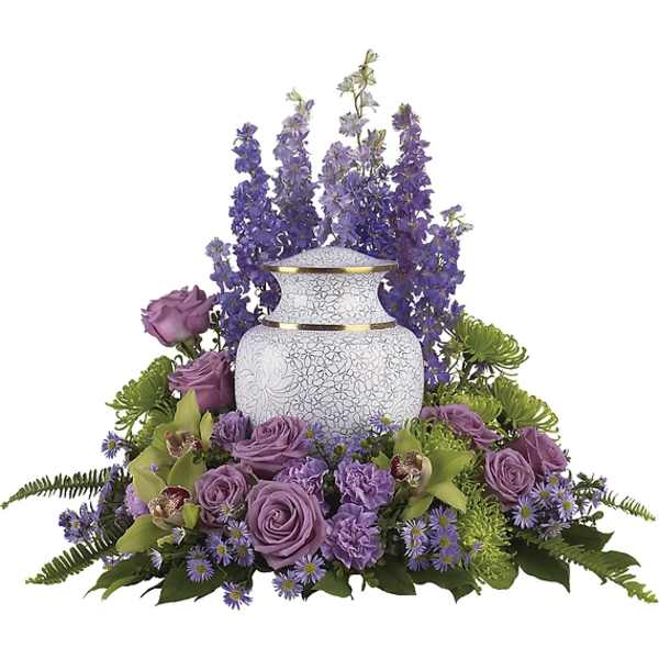 Purple floral arrangement around a white urn vase