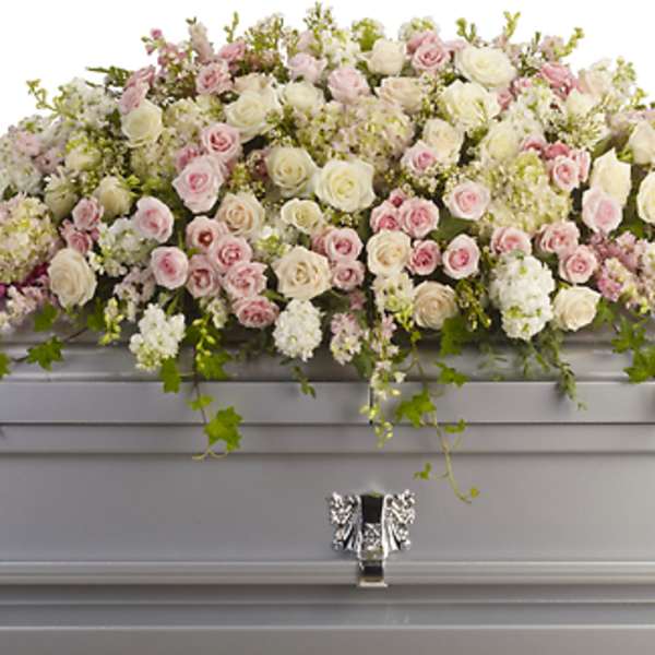 Pastel rose and hydrangea casket spray on a silver casket