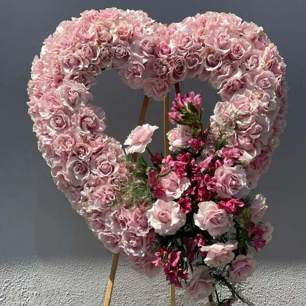 Heart-shaped pink rose floral display on an easel