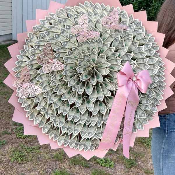 Large bouquet made of folded dollar bills with pink ribbon and butterfly accents