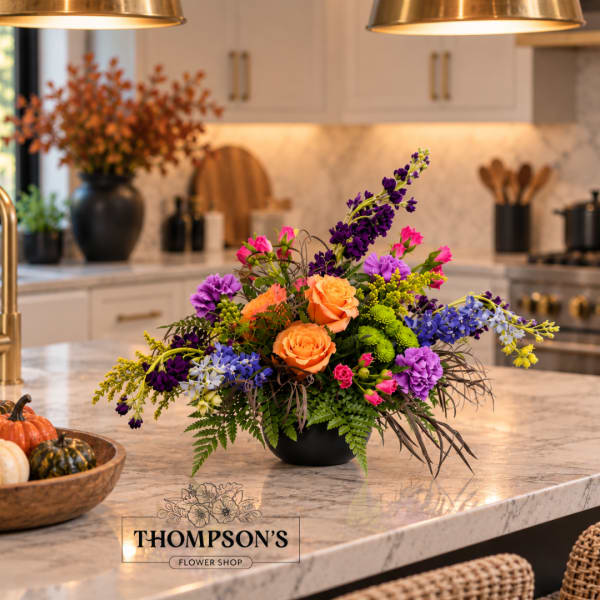 Colorful flower arrangement in a black bowl on a kitchen island