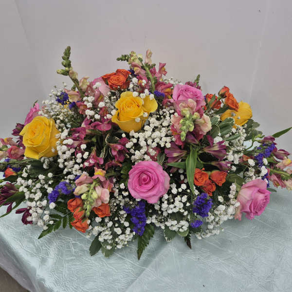 Large mixed bouquet with pink, yellow, and orange roses and small white filler flowers