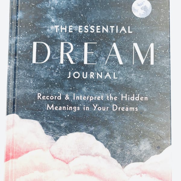 A book cover titled The Essential Dream Journal with a cloudy night-sky design