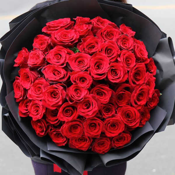 Bouquet of red roses wrapped in black paper