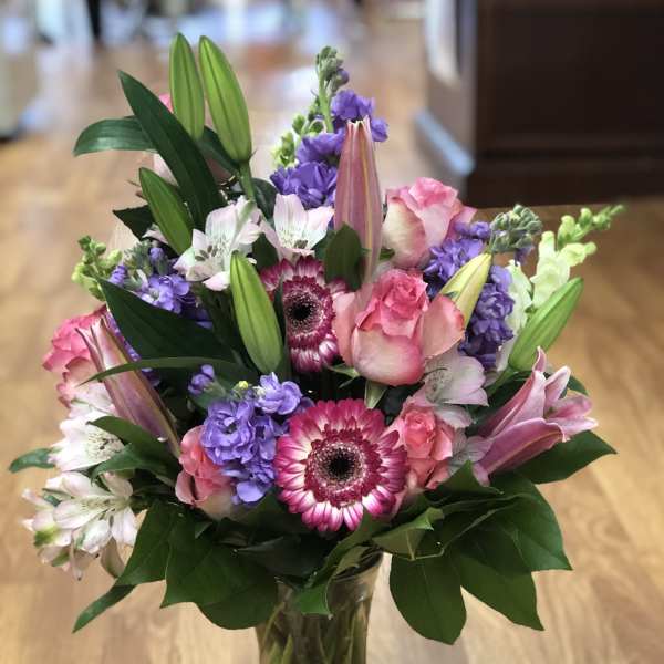 Pink and purple mixed bouquet in a clear glass vase