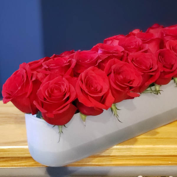 Long white box filled with red roses