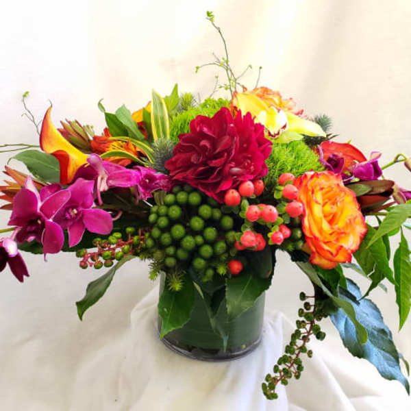 Bright mixed bouquet in a glass vase with orange, pink, and yellow blooms