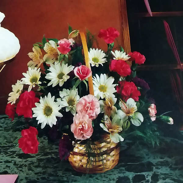 Basket arrangement of daisies, carnations, and roses