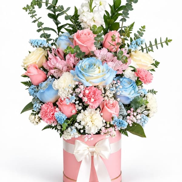 Pastel bouquet of roses, carnations, and filler flowers in a pink hatbox with a bow