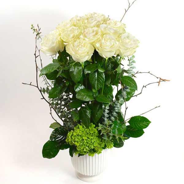 White roses and green hydrangea in a white vase