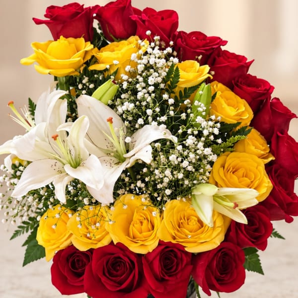 Bouquet of red and yellow roses with white lilies and baby's breath
