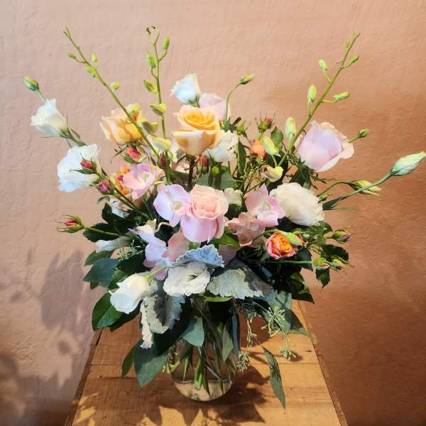Pastel rose and lisianthus arrangement in a glass vase
