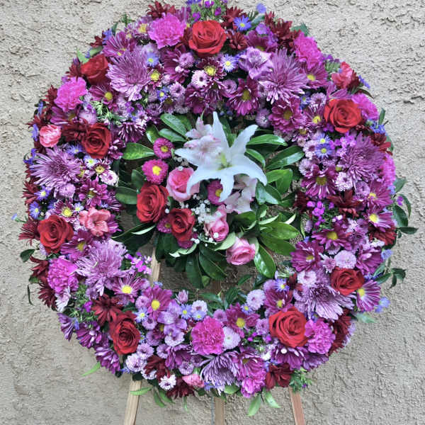 Large circular floral wreath with pink, purple, and red flowers