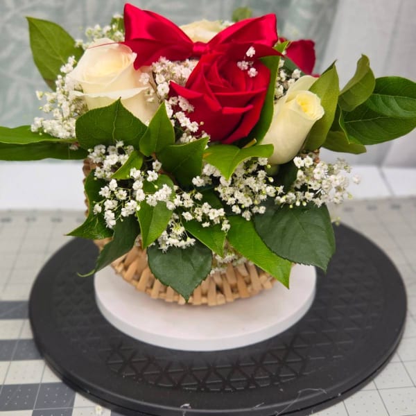 Red and white roses with baby's breath in a basket