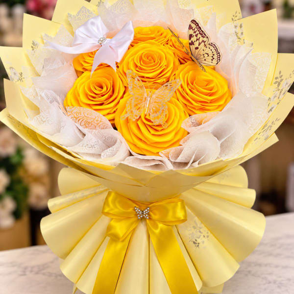 Yellow rose bouquet with butterfly decorations and a satin bow