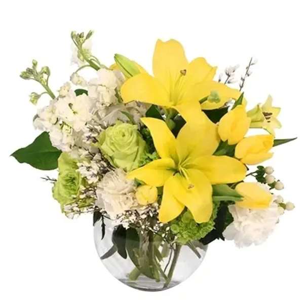 Yellow lilies and white flowers in a clear glass vase