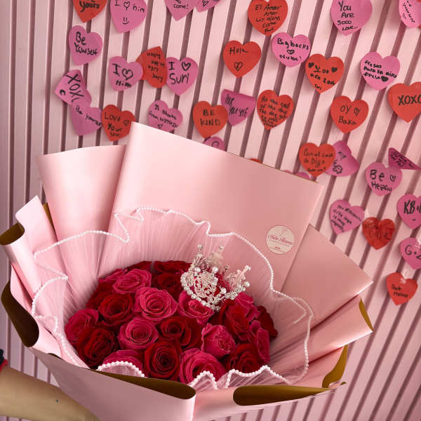 Bouquet of red and pink roses wrapped in pale pink paper