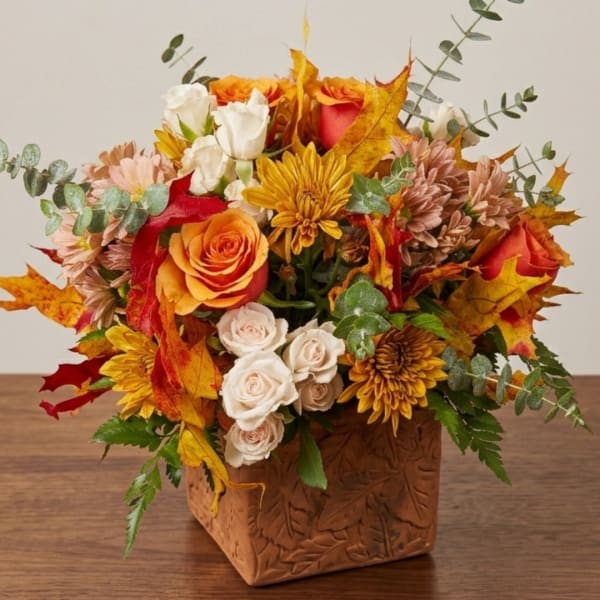 Autumn bouquet of roses and mums in a carved square vase