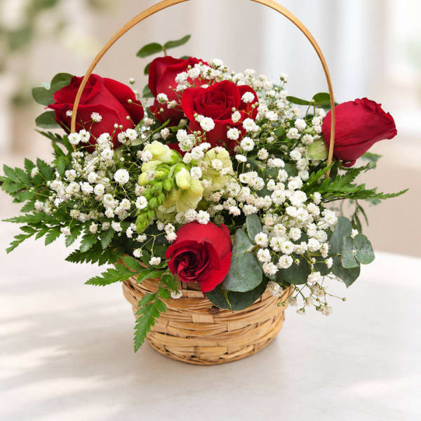 Basket arrangement of red roses and white baby's breath