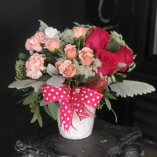 Pink and red rose bouquet in a white pot with a polka-dot ribbon