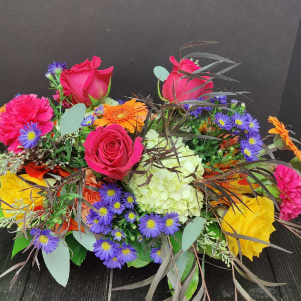 Mixed bouquet with pink roses, purple daisies, and orange gerberas