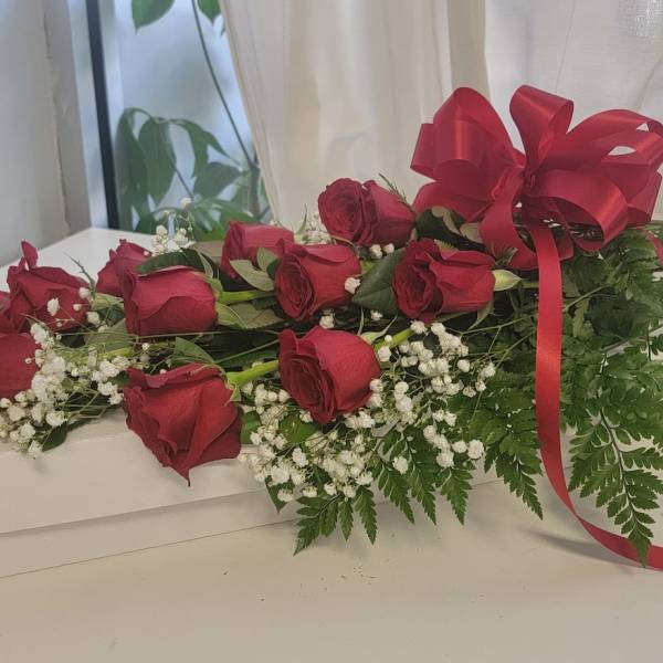 Long-stem red roses with baby's breath and a red ribbon on a white box