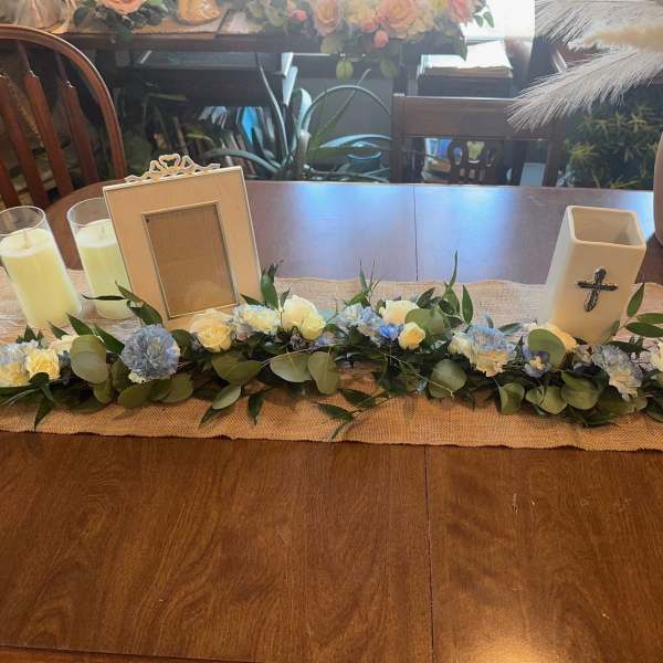Low floral garland with white and blue blooms on a table