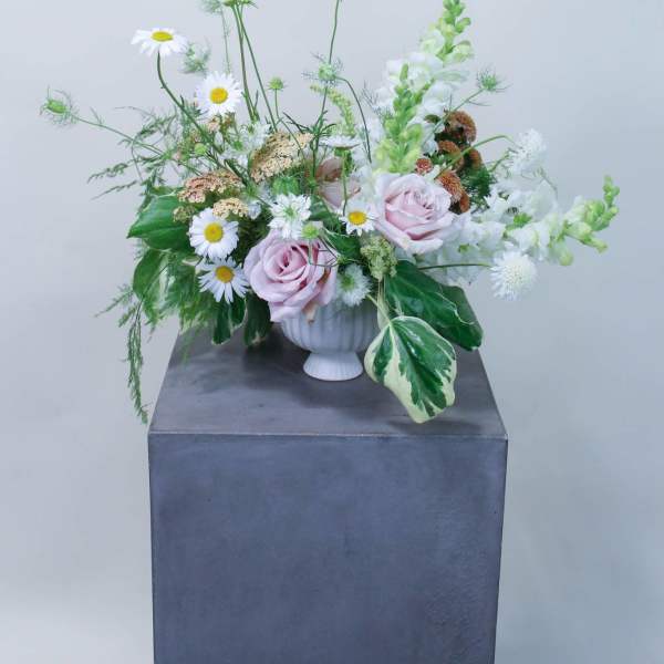 Pastel floral arrangement with pink roses and white daisies in a white vase
