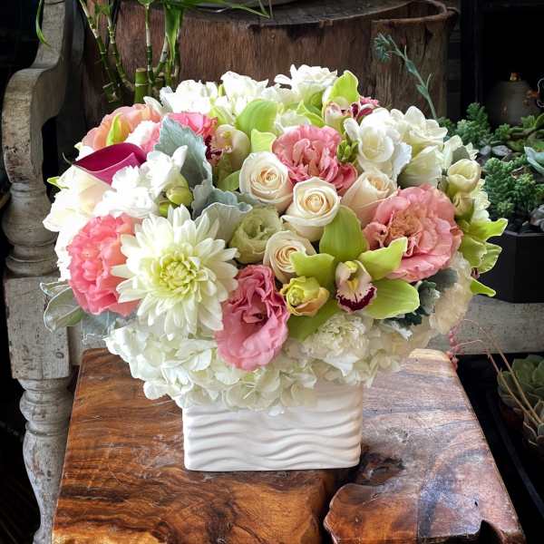 Bouquet of pink, white, and green flowers in a white vase