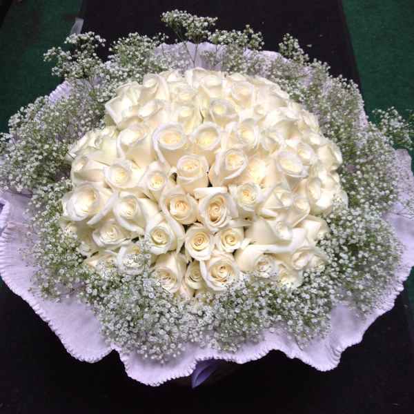 Round bouquet of white roses with baby's breath