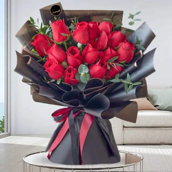 Bouquet of red roses wrapped in black paper with a ribbon