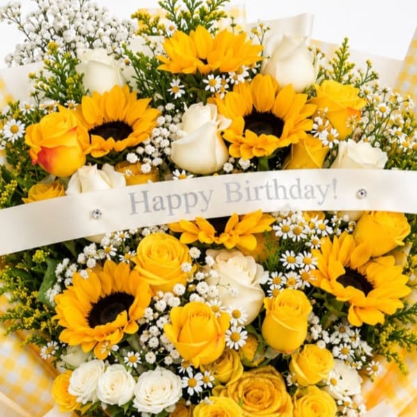 Yellow and white bouquet with sunflowers, roses, and daisies, wrapped with a birthday ribbon
