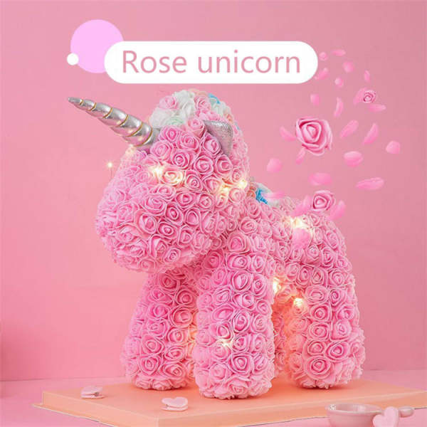Pink rose-covered unicorn figure with a silver horn on a pink background