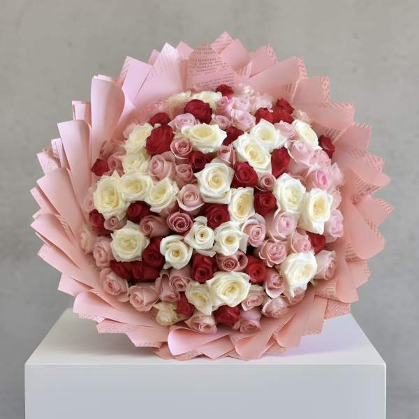 Bouquet of pink, red, and white roses wrapped in pink paper