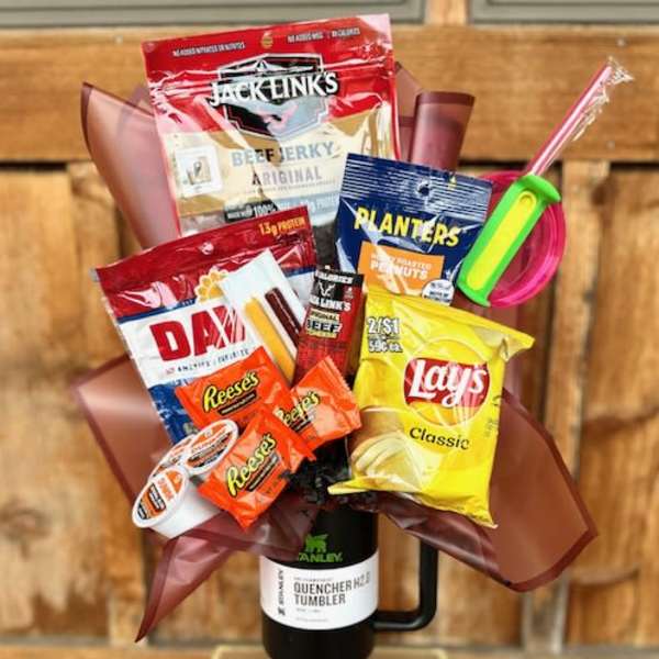 Snack bouquet in a black tumbler with chips, candy, jerky, and peanuts