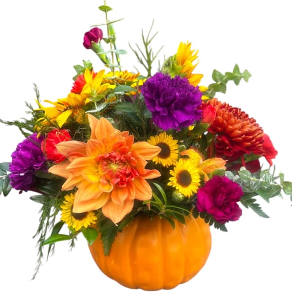 Mixed bouquet in an orange pumpkin container with bright yellow, orange, red, and purple flowers