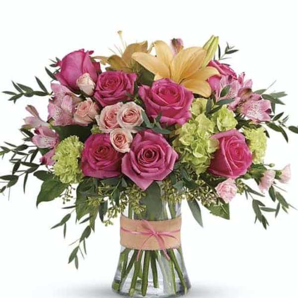 Pink and yellow flower bouquet in a clear glass vase