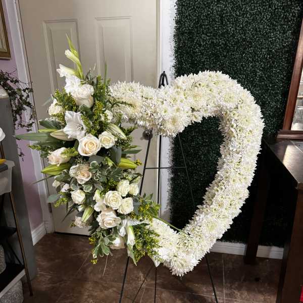 White floral heart-shaped standing spray on an easel