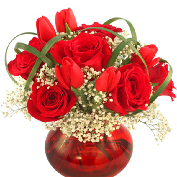 Red roses and tulips in a red glass vase