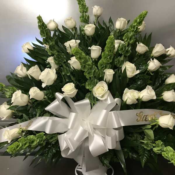 Large white rose arrangement with a silver ribbon bow