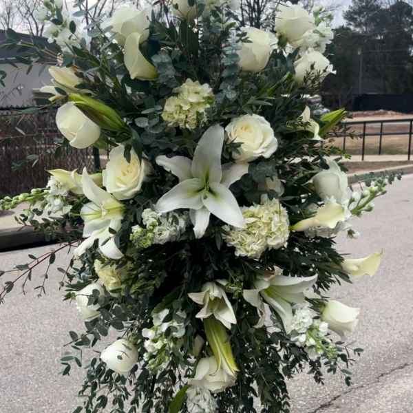 Large white floral standing spray with lilies and roses
