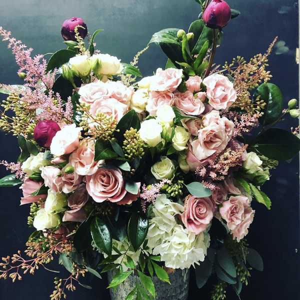 Pink and white rose arrangement in a gray vase