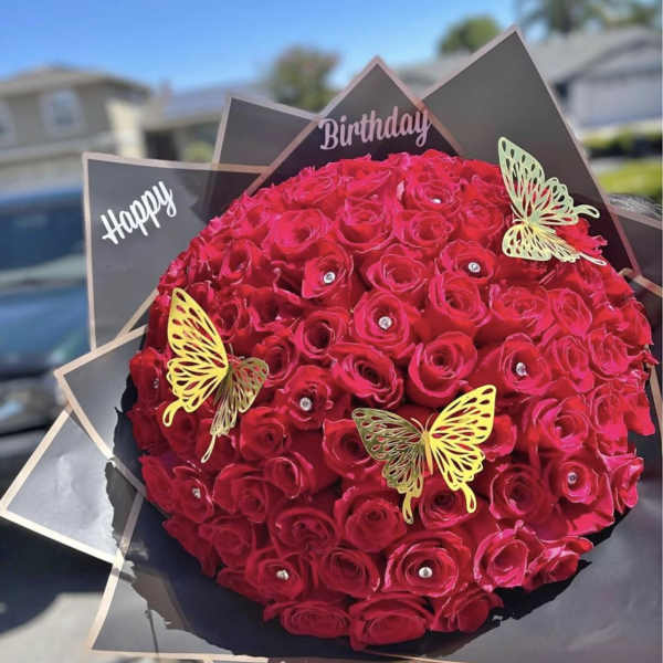 Round bouquet of red roses with butterfly decorations and birthday signs