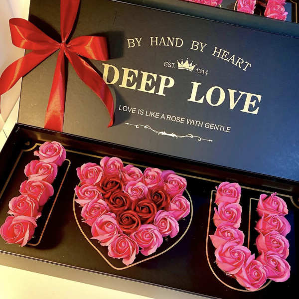 Heart-shaped rose box with pink and red roses and a red ribbon