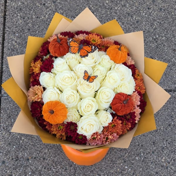 Bouquet of white roses and autumn chrysanthemums with small pumpkins and butterfly picks