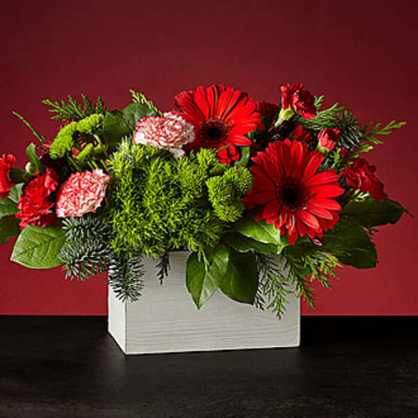 Red and pink mixed flower arrangement in a white box