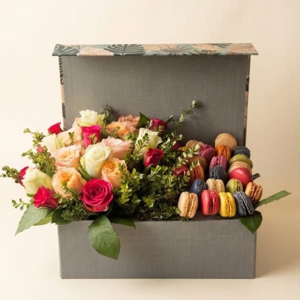 Box of roses with colorful macarons arranged beside them